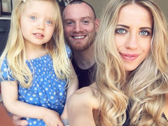 A young couple Amy and Joel pose with their very young daughter for a selfie.