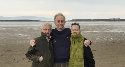 A group shot of Jasmine and her mum and dad on a windswept beach near the Wirral