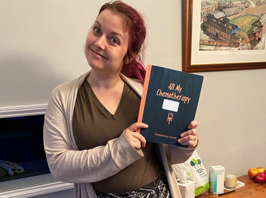 A woman poses with a book titled "All My Chemotherapy"