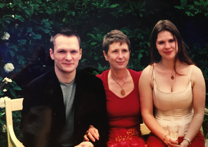 A family photograph of three people - a mother Misha and her two grown-up children. Posy is on the right.