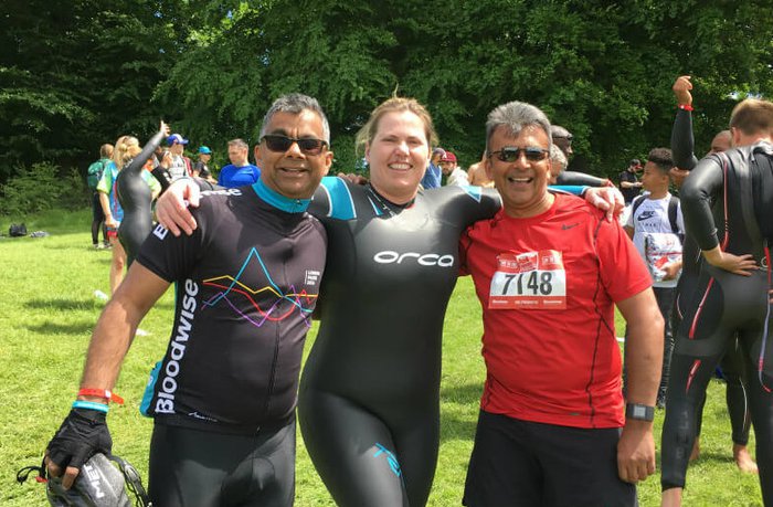Three participants post at a triathlon together.
