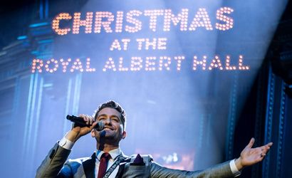 A singer finishes a song, arms outstretched, onstage at Christmas with the Stars at the Royal Albert Hall