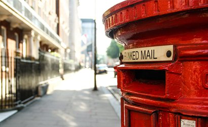 A red London postbox on a city street
